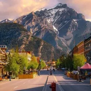 A street in Banff with mountains in the background.