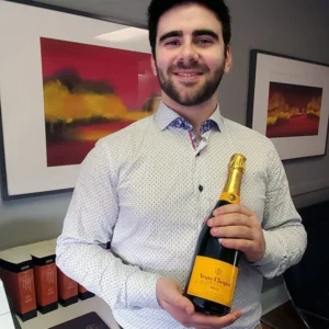 Man in collared shirt holding bottle of champagne