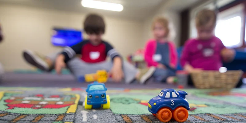 Three children in preschool with toy cars
