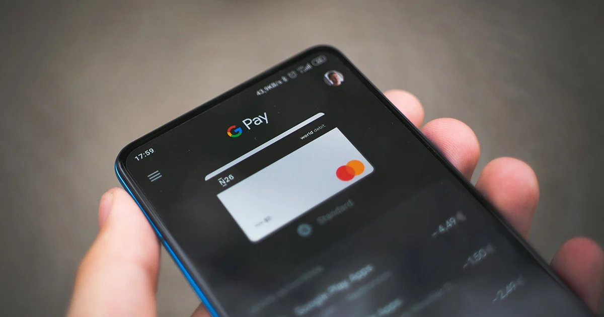 Hand holding a smart phone with the Google Pay app.