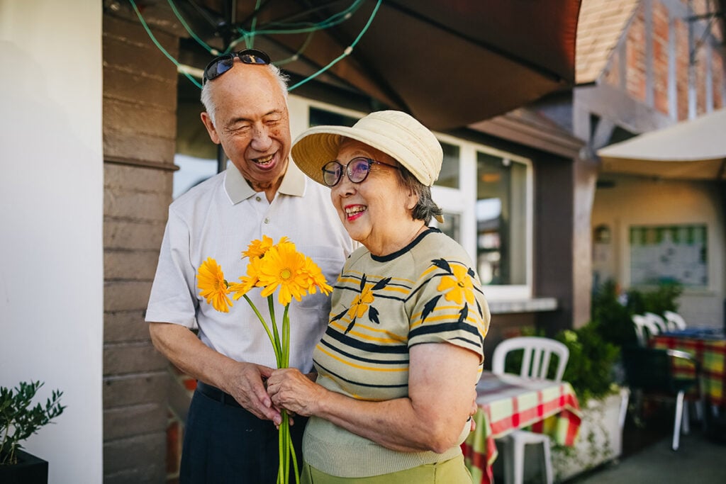 Grandmother and grandfather holding flowers