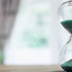 Glass hourglass with green sand