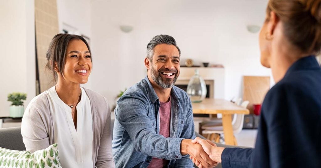 Couple shaking hands with a consultant