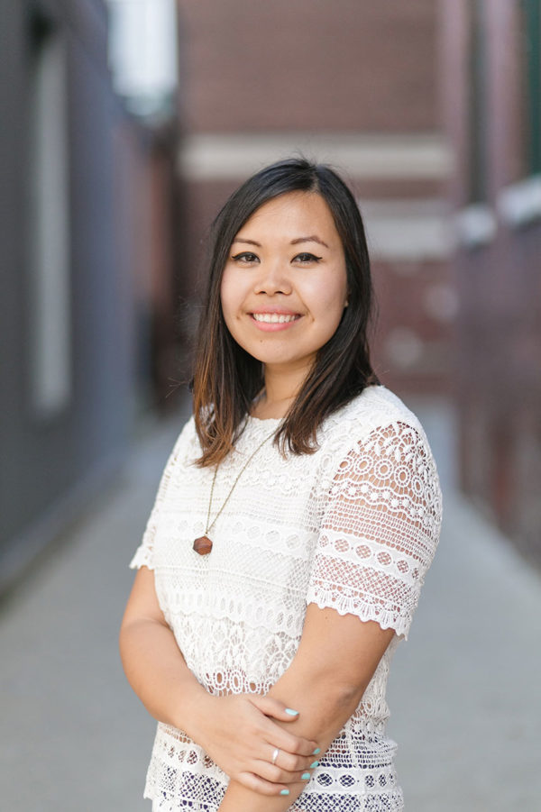 Woman standing, angled toward camera and smiling