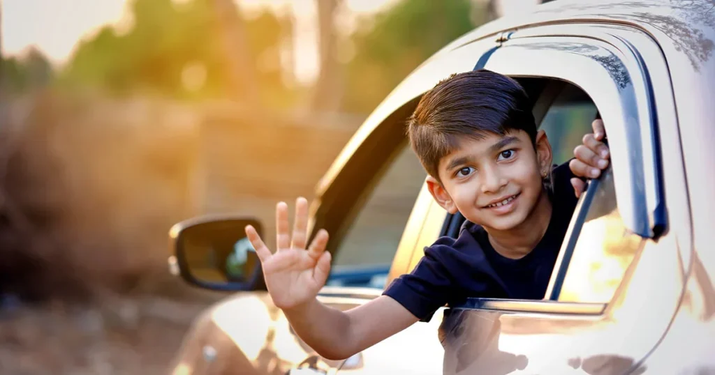 Indian boy waving out car window module