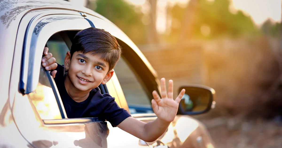 Indian boy waving out car window module