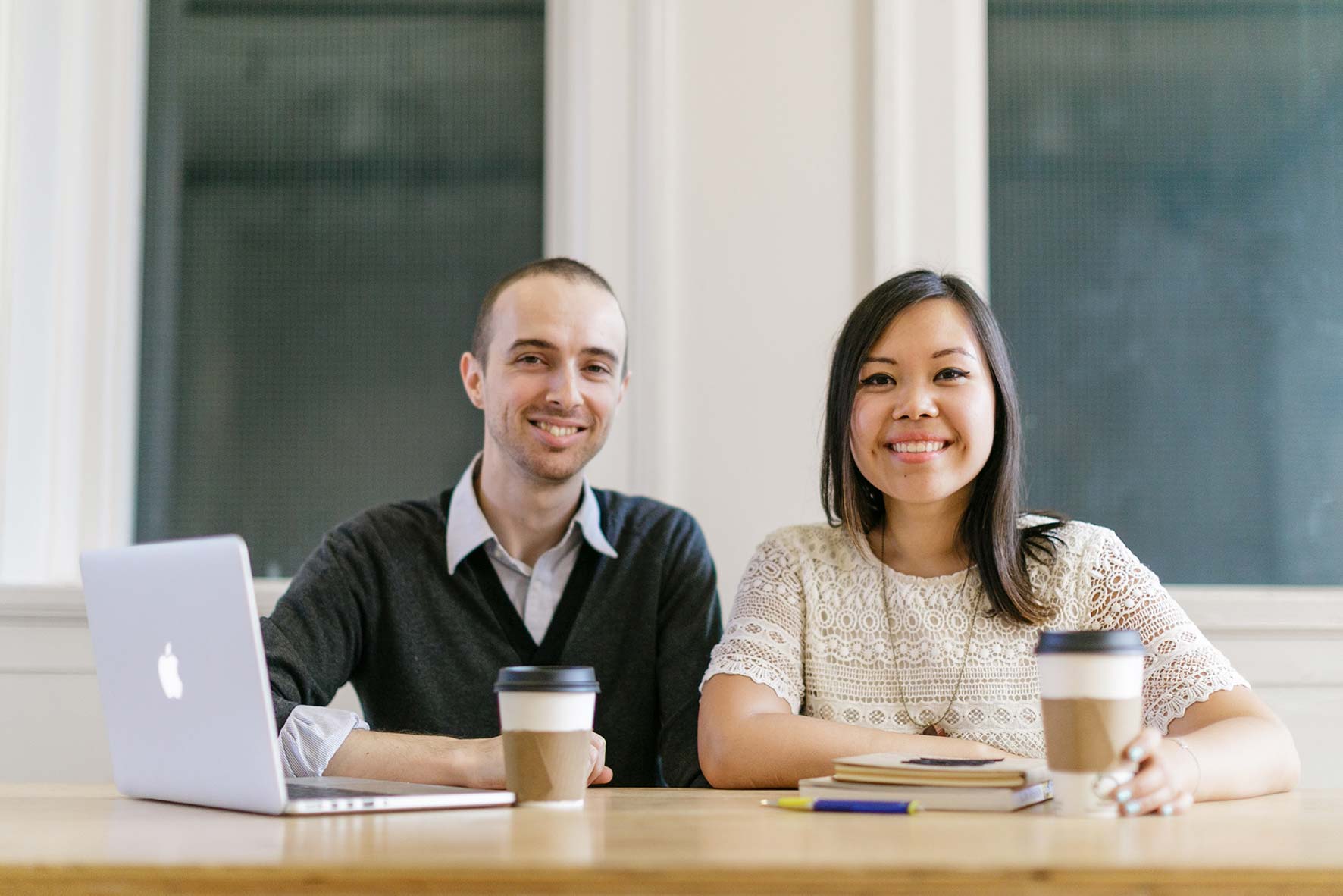 Man sitting next to woman at a desk