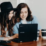 Two people working on a laptop.