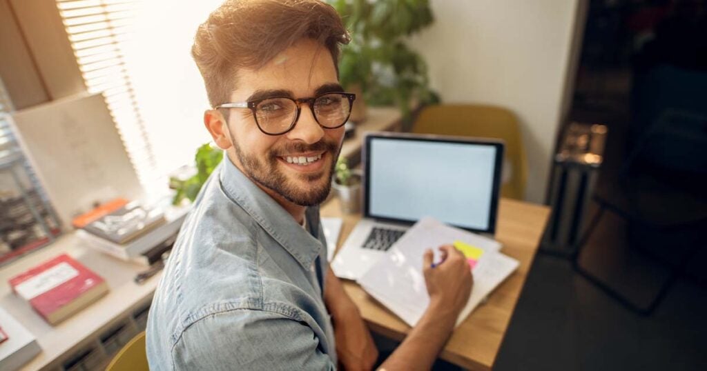 Smiling young man at laptop