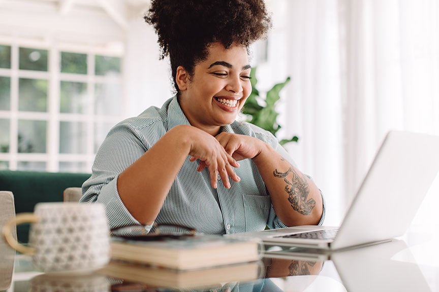 Smiling young woman at a laptop