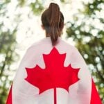 A woman wears a Canadian flag in anticipation of a new immigration pathway