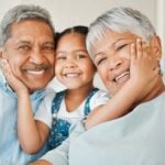 grandparents on couch with grand daughter