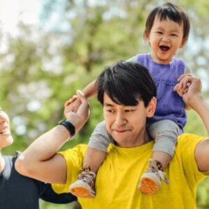 young asian family with daughter on shoulders