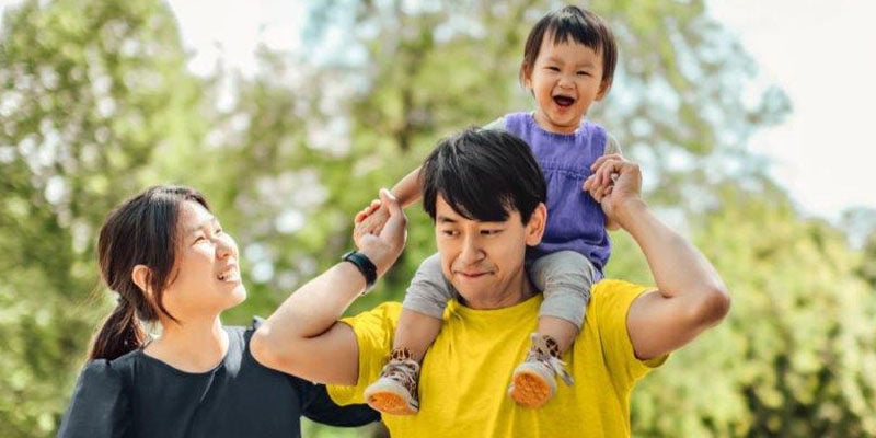young asian family with daughter on shoulders