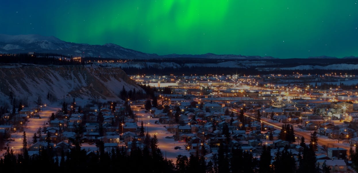 Strong northern lights (Aurora borealis) substorm on night sky over downtown Whitehorse, capital of the Yukon Territory, Canada, in winter.