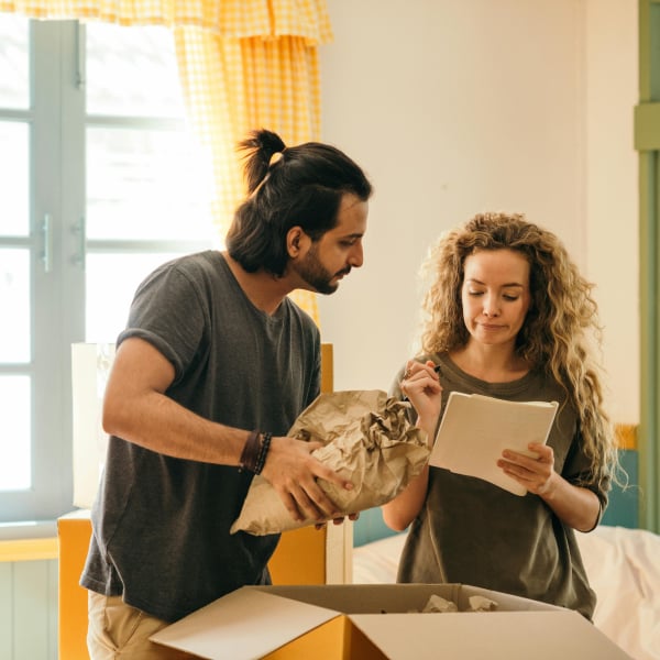 Male and female couple unpacking a box in their new rental apartment