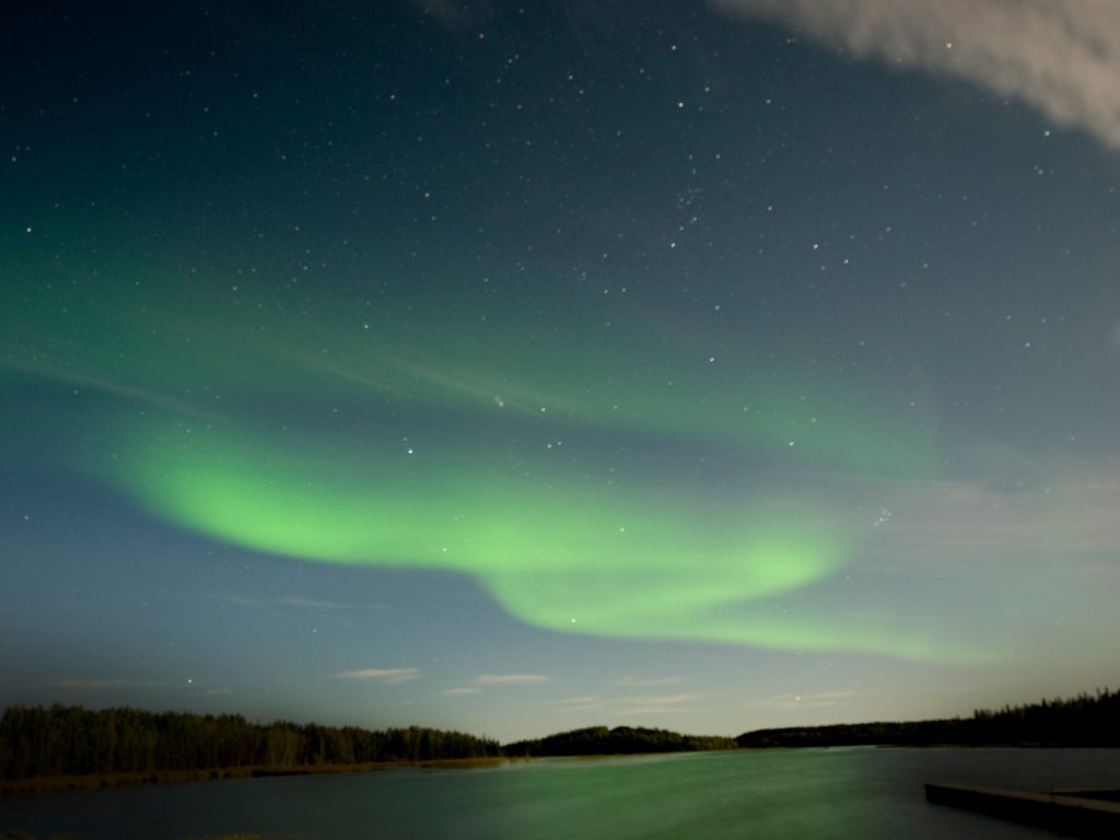 Vibrant green and purple auroras dancing across the night sky