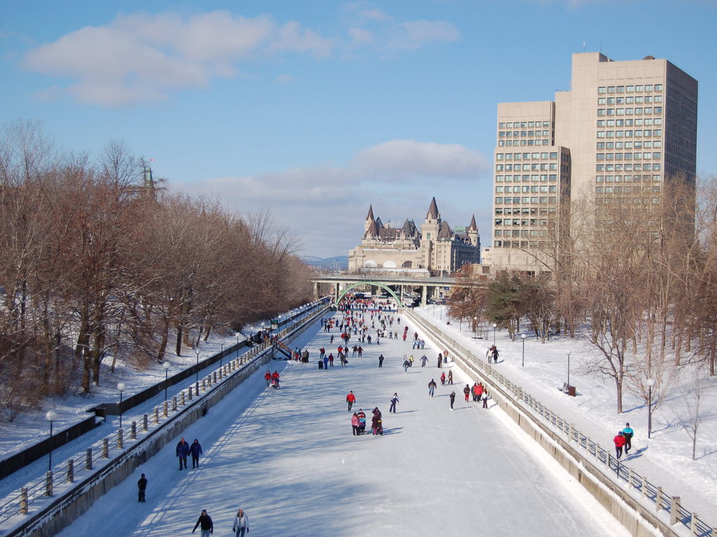 Skaters gliding along the frozen Rideau Canal in Ottawa, Ontario, during a snowy winter day.