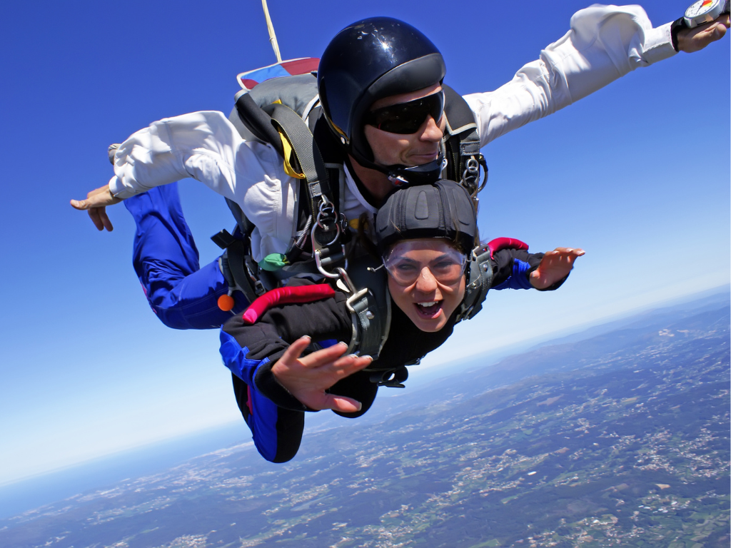 A skydiver in freefall over the vast, open landscapes of Saskatchewan