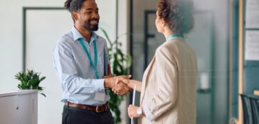 Two professionals shaking hands indoors.