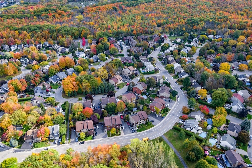 Aerial view of residential neighborhood showing trees changing color during fall season in Montreal, Quebec, Canada.