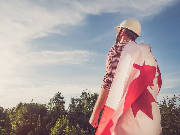 Attractive engineer, holding an Canadian Flag in the park