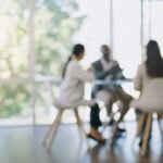 Business meeting, blurred background and people in office for teamwork, collaboration and planning, Partnership, negotiation and group in solidarity for growth, consulting and corporate solution