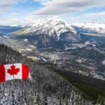 Canada's flag overlooking mountains in Banff