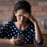 Worried woman checks her phone