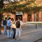 Group of students walking across a campus